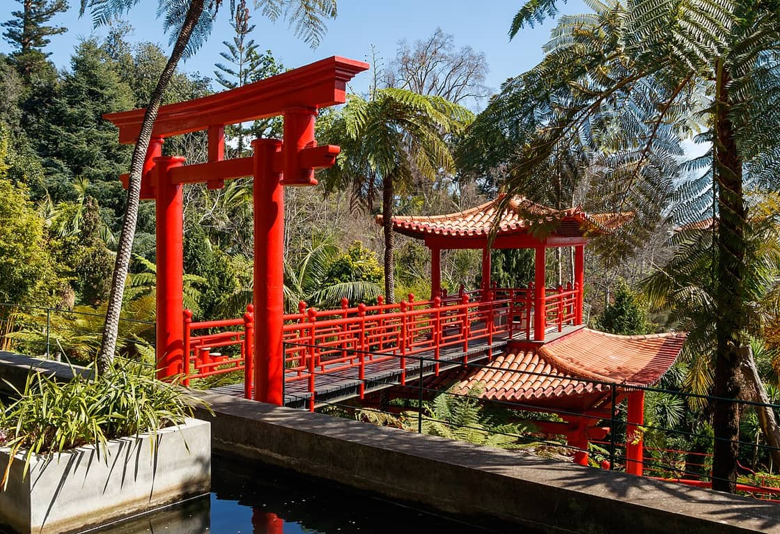 Eine rote Brücke und ein Ziertor im Monte-Palace-Garten säumen die Wege des Gartenrundgangs.