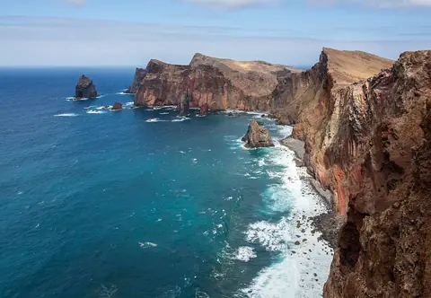 Rote Klippen und blaues Wasser an der Ponta de São Lourenço prägen die offene Küstenwanderung.